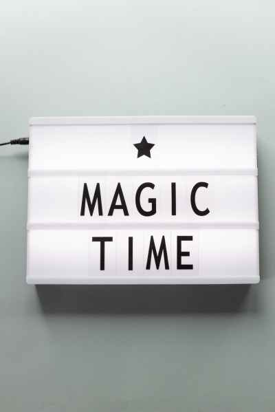 A image of a plugged in, white light up sign with a star and the words Magic Time in black, centered on the sign.