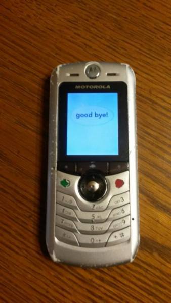 A picture of a silver metal bar phone with the words "Good bye!" on the screen.